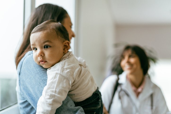 Women, Infants, and Children (WIC) 1 Mother holding a baby at a doctor's office